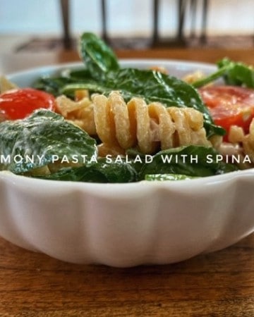 Pasta Salad with Spinach for healthy eyes in white bowl on wood