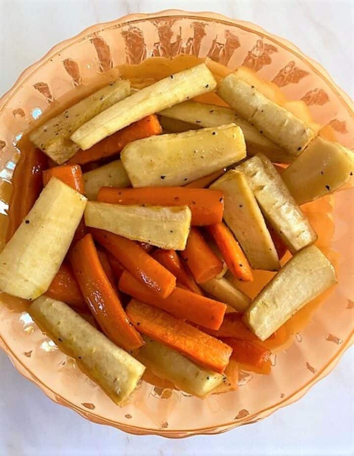 Shiny orange bowl with white parsnip and orange carrot logs