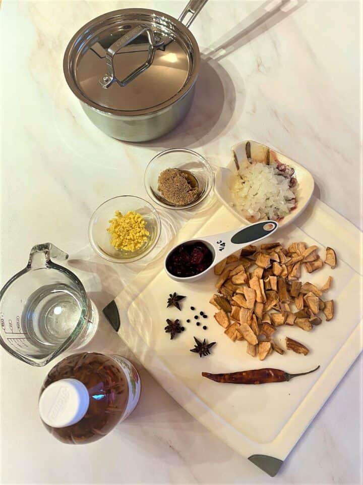 Dried pears, cranberries, onion, spices, chile, vinegar, etc shown as ready for pear cranberry chutney