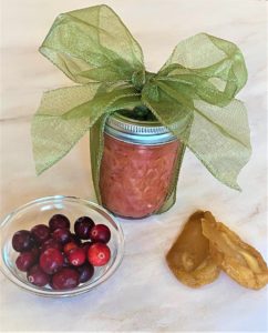 jar of pear-cranberry chutney with a ribbon + dried pear and cranberry garnish