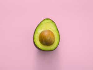 Avocado half on pink background