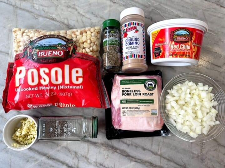 A bag of fresh hominy corn, container of red chile, pork roast, onions, and spices needed for Pozole
