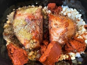 slow cooker with ingredients (including pork roast) for starting posole, without water