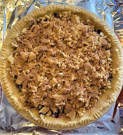 unbaked blueberry pie with crumb topping and oil crust