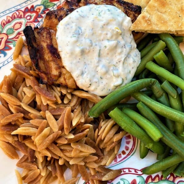 dinner of grilled chicken with yogurt sauce, orzo, green beans and naan
