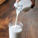 Milk being poured from a bottle into a glass