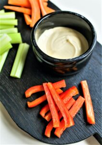 fresh veggies sticks and dip on a black board