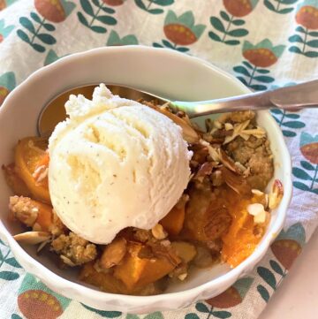 Dish of apricot crumble with a scoop of ice cream