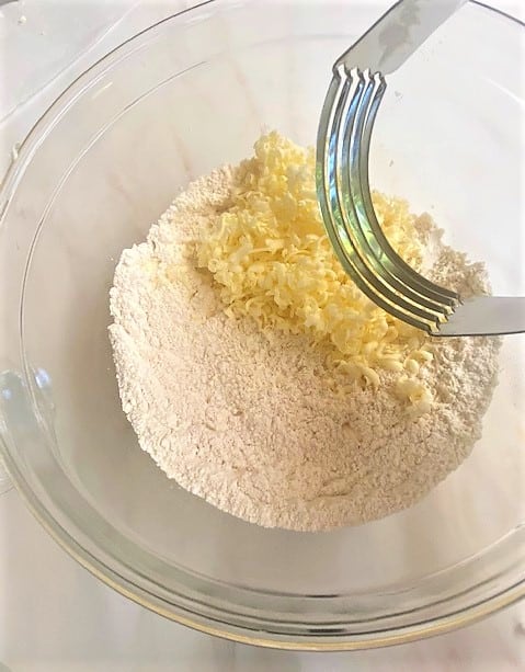 Pastry cutter working grated butter into dry scone ingredients