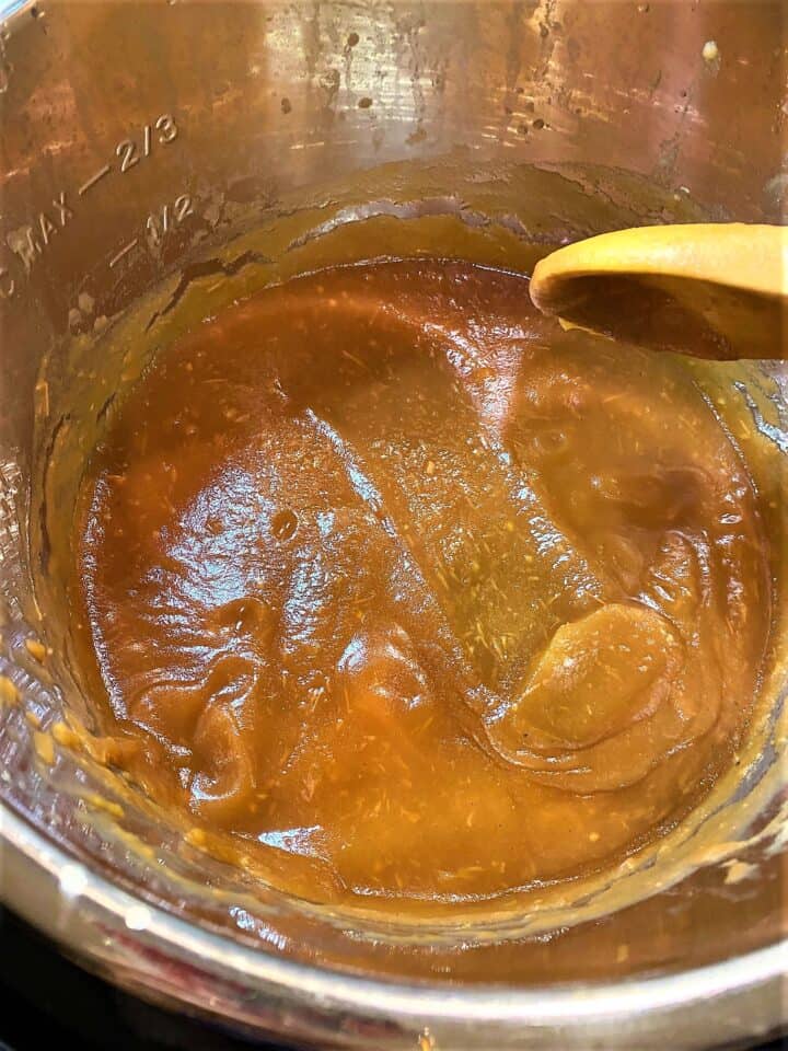 Thickened apple butter in recipe card with trail in the butter left by spoon