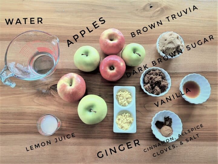 red and green apples, spices, sugar, water and lemon juice on wooden background