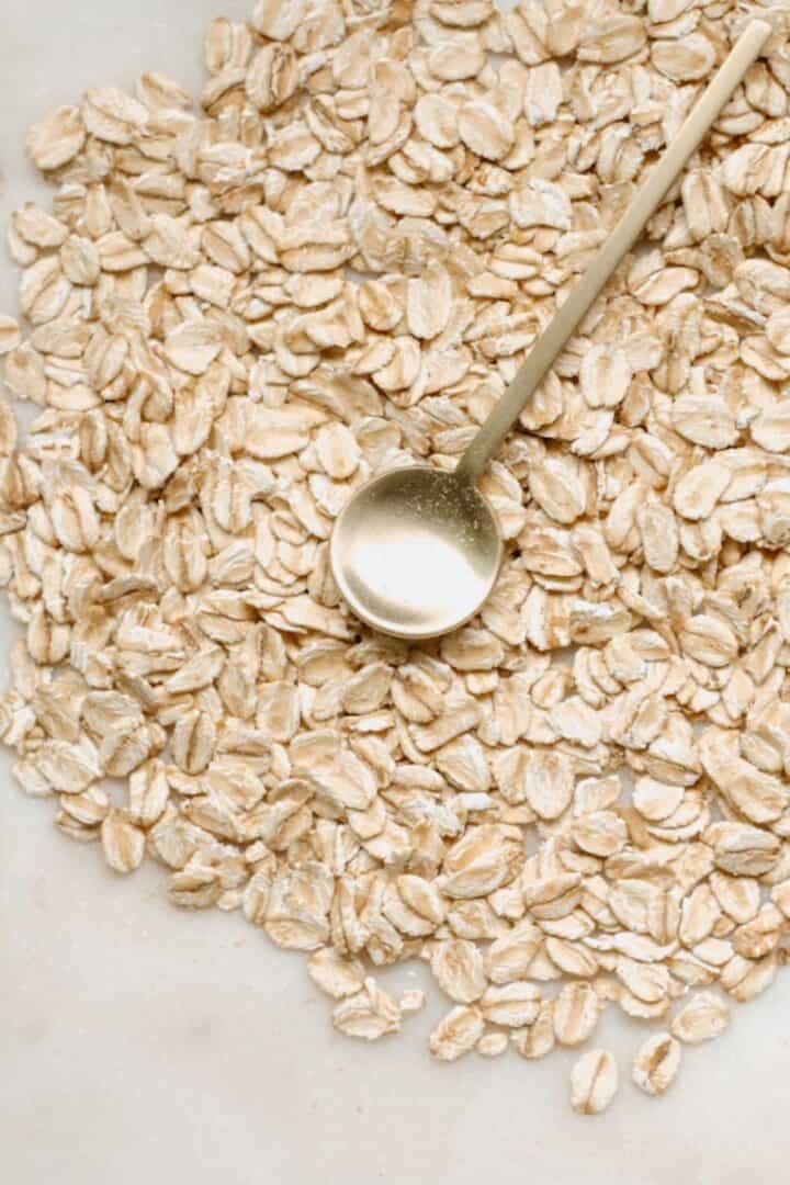 Golden spoon with round head in the middle of light brown oats.