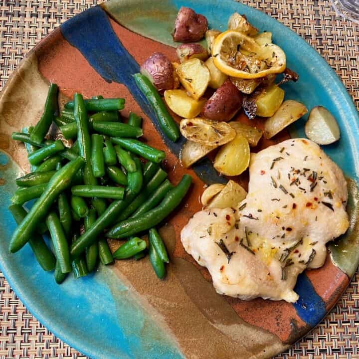 Southwestern pottery dinner plate with chicken thigh, potatoes and lemon, and green beans