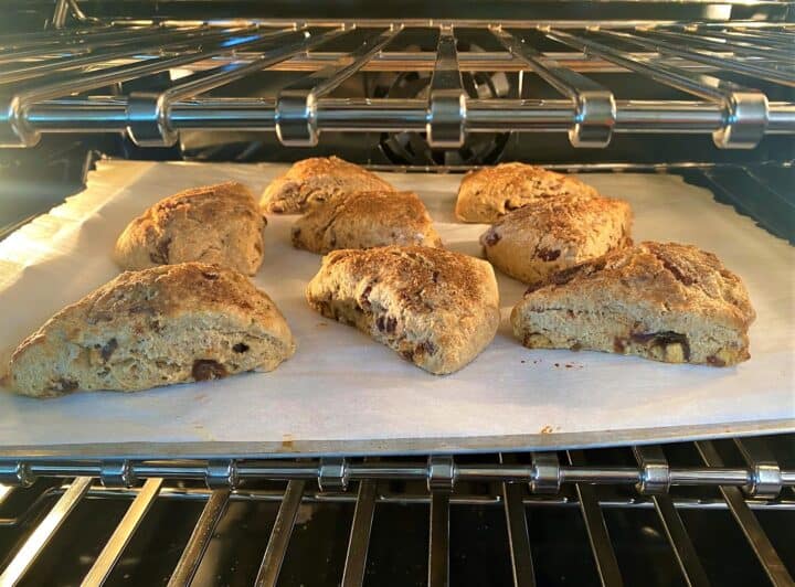 Date scones on baking sheet lined with parchment baking in the oven