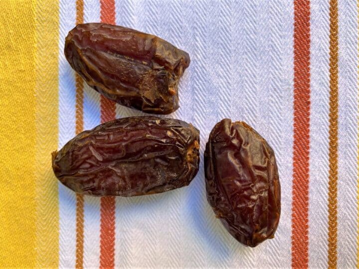 three dates on a yellow and red striped kitchen towel