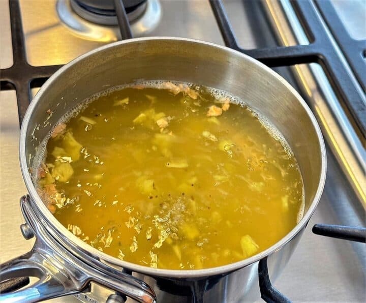 Ginger bits boiling for tea in water in saucepan.