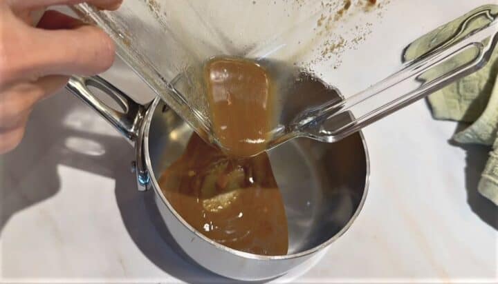 Pouring brown liquid from baking dish into a small saucepan