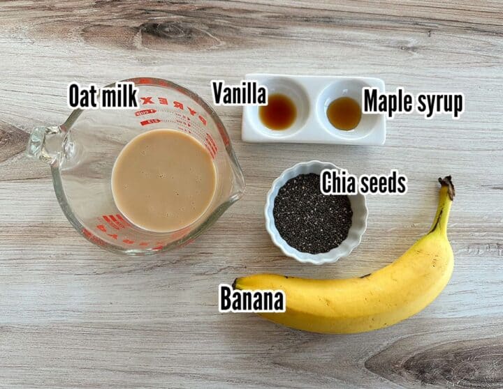 Oat milk, banana, chia seeds, and flavorings shown with labels on a wooden background