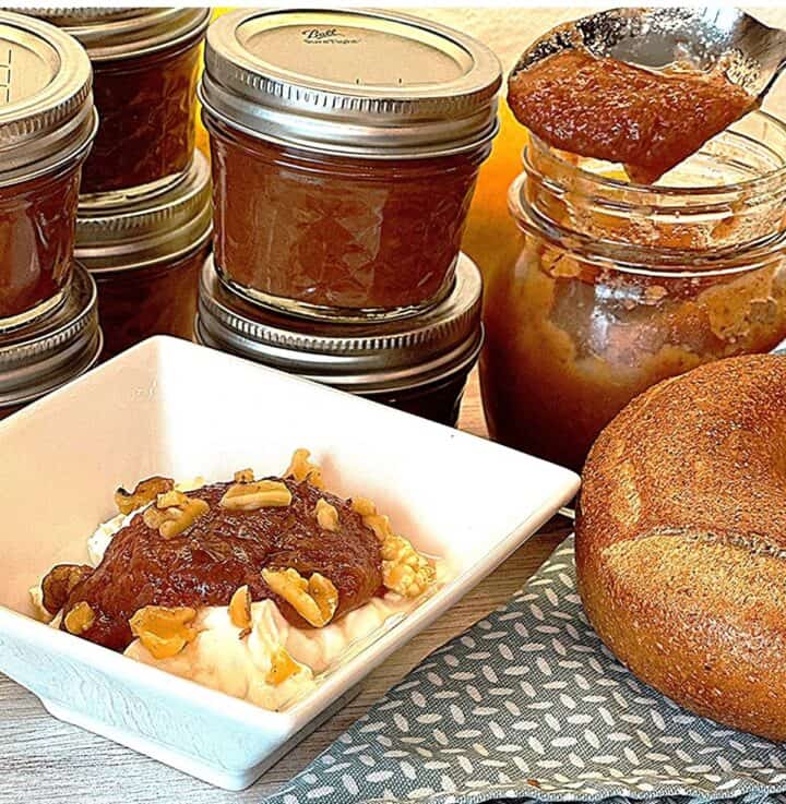 Small jars of caramel colored pear butter, plus the thick brownish butter on a spoon and topping plain yogurt in a white dish.