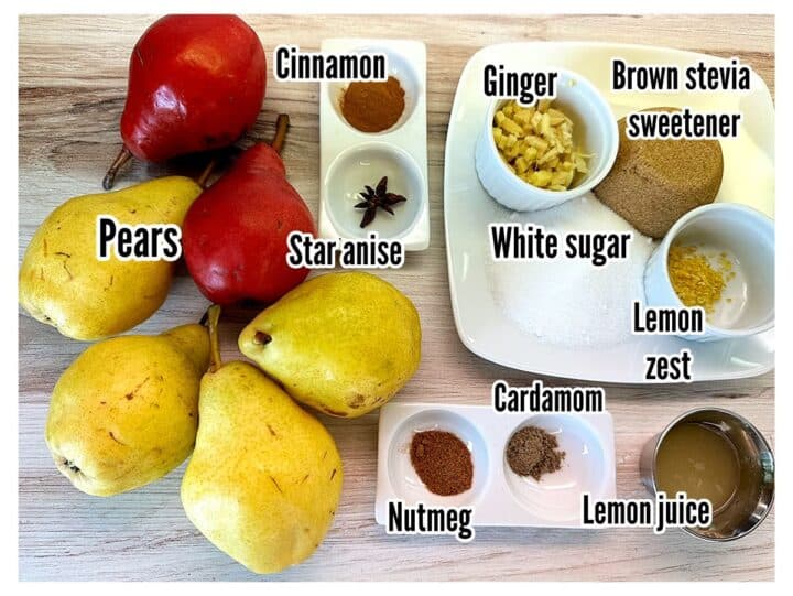 Red and yellow pears, spices, sugar shown on a wooden background.