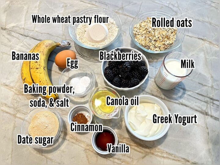 A dozen ingredients including blackberries, flour, dairy, bananas, oil, and oats with labels for oat muffin recipe.