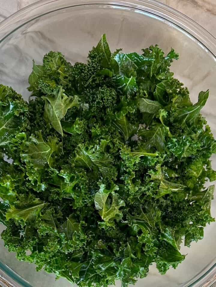 Chopped dark green curly kale in a clear bowl.