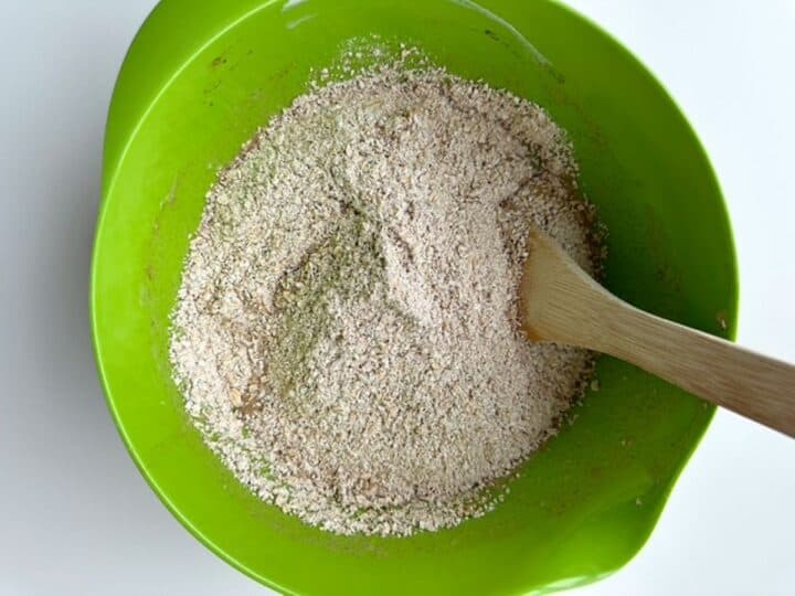 Coarse tan oat flour in a lime green mixing bowl.