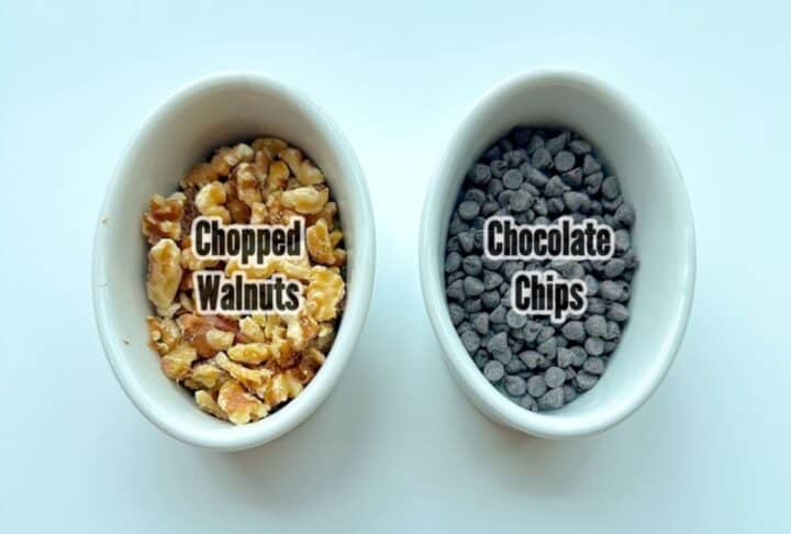 White oval ceramic containers with walnuts and mini chocolate chips.