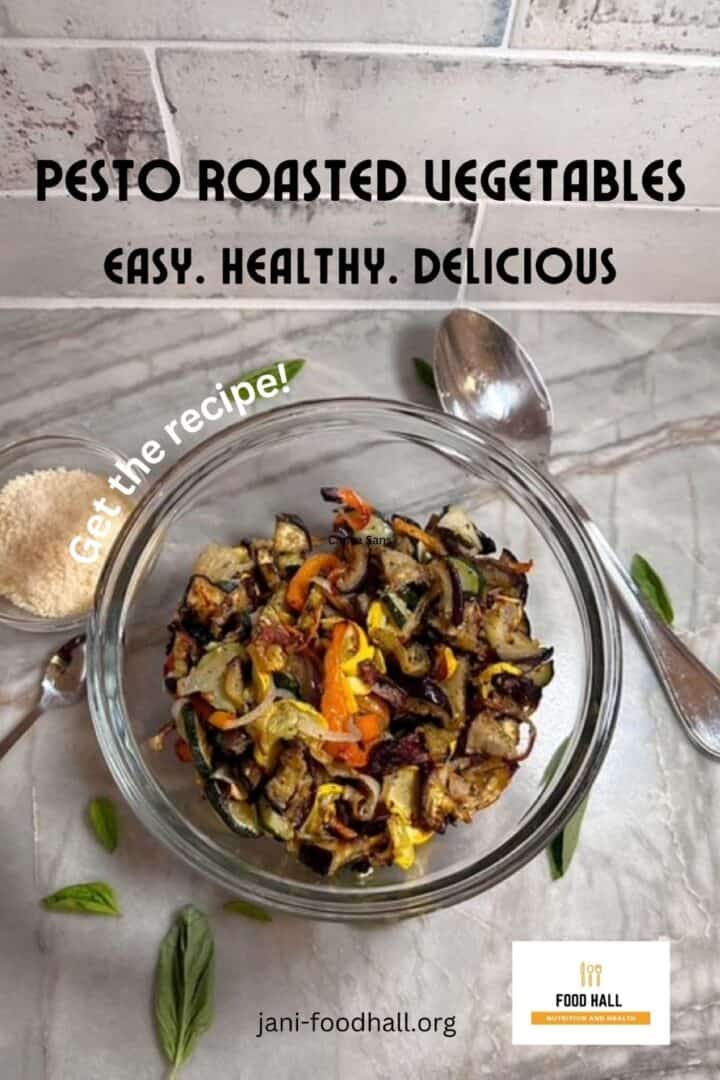 Clear bowl of roasted veggies on a gray marble counter with some grated Parmesan on the side.