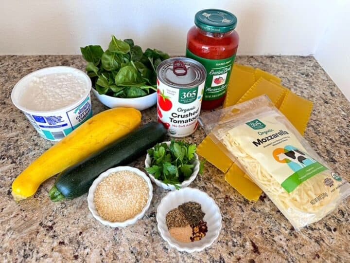 Tomato pasta sauce, zucchini, cheeses, spices, spinach, parsley, lasagna noodles for Crockpot Vegetables Lasagna.