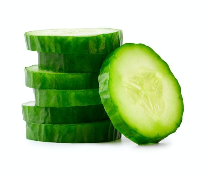 Stack of sliced cucumbers, green and white with no background.