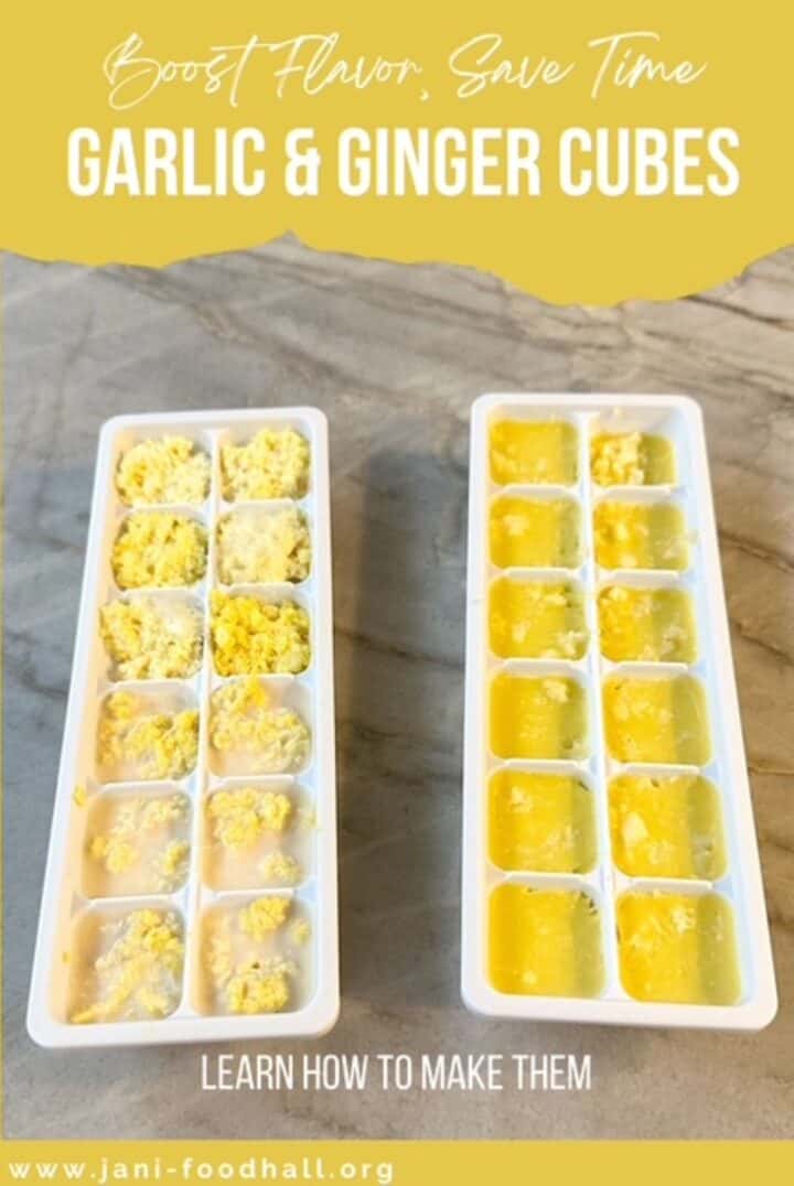 Two white ice cube trays hold frozen yellow cubes of garlic and ginger.