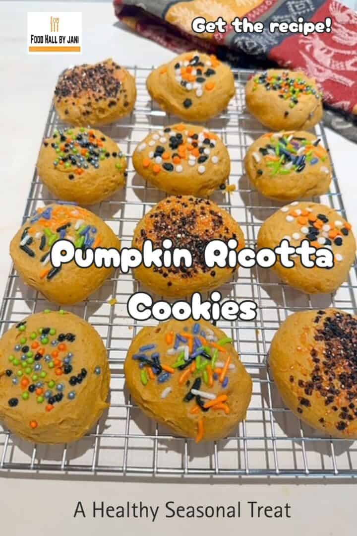 Wire rack filled with Halloween decorated round and golden pumpkin ricotta cookies.