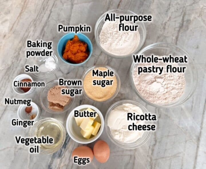 Flours, pumpkin, ricotta, eggs, and other ingredients needed for pumpkin ricotta cookies.