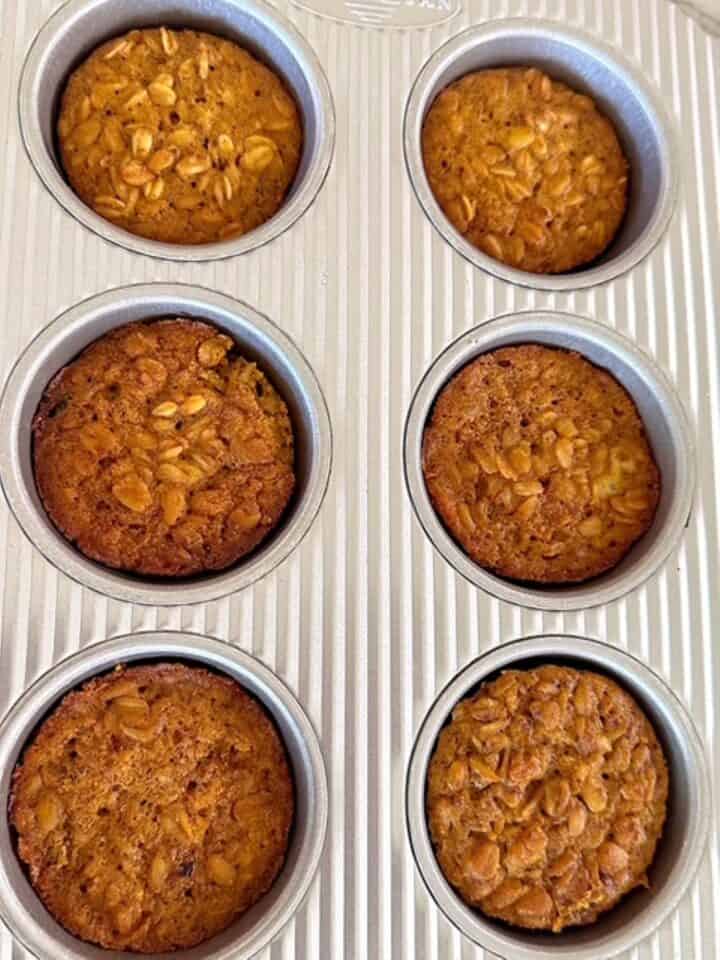 Six golden brown pumpkin baked oatmeal cups in a corrugated 6-cup muffin tin