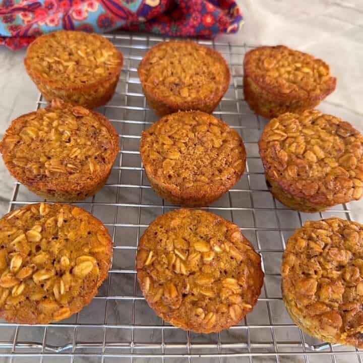 Dark golden Pumpkin Baked Oarmeal Cups cool on a wire rack.
