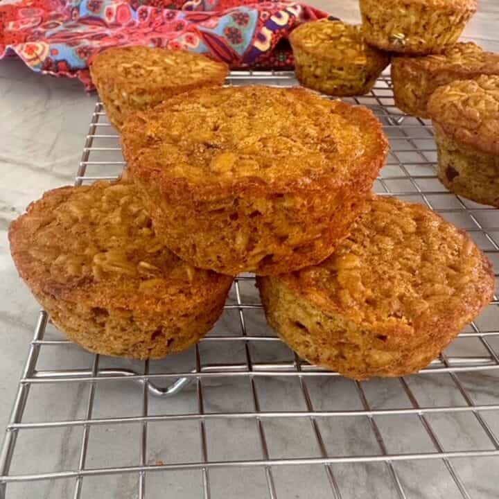 Silver wire cooling rack with stack of three golden pumpkin oatmeal cakes.