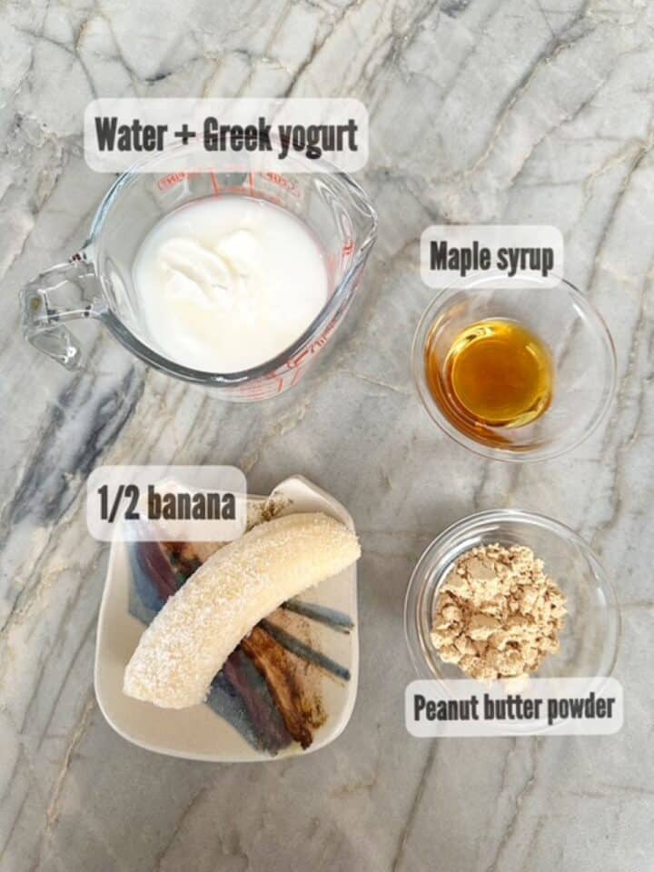 White Greek yogurt, creamy banana, brown maple syrup, and brownish peanut butter powder ingredients for peanut butter powder smoothie