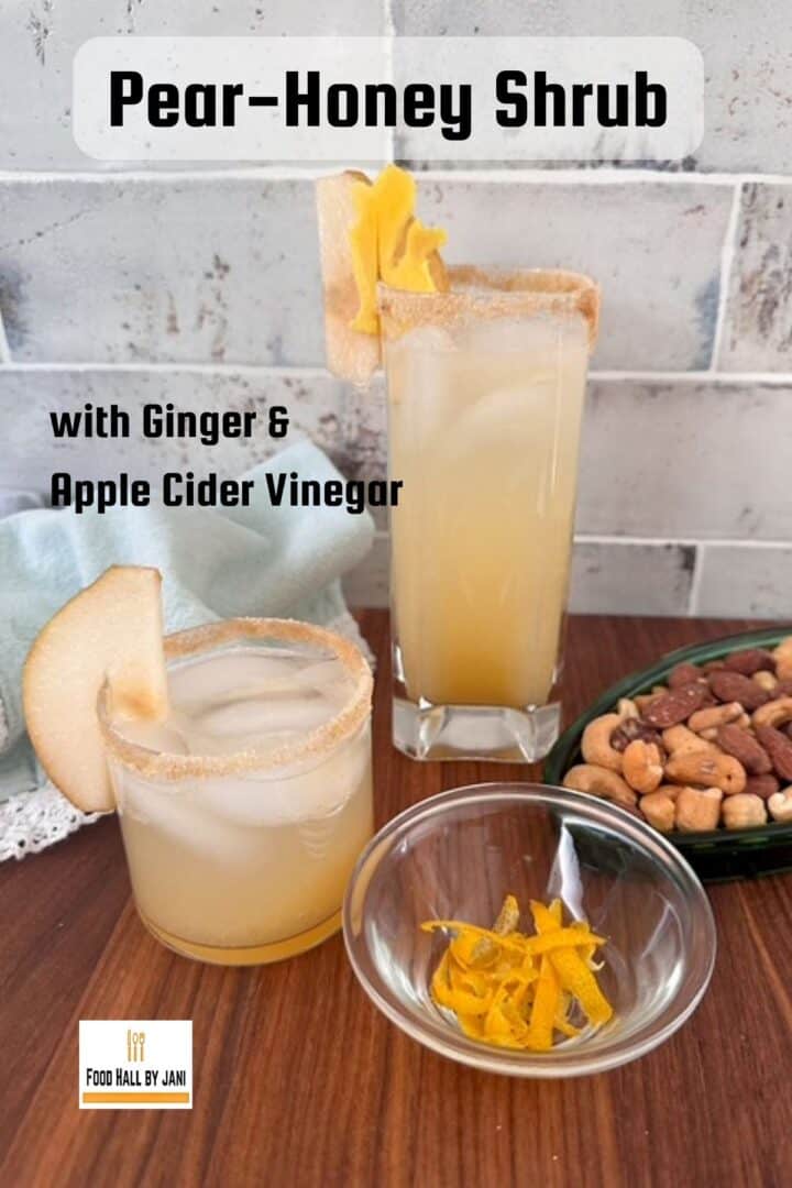 Two festive light yellow drinks next to a green dish of nuts.