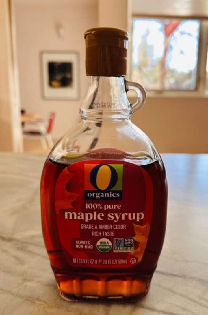 Clear bottle full of brown maple syrup