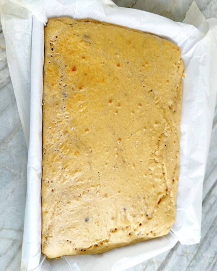 Golden, rectangular sheet pan pancake in parchment ready to cut.