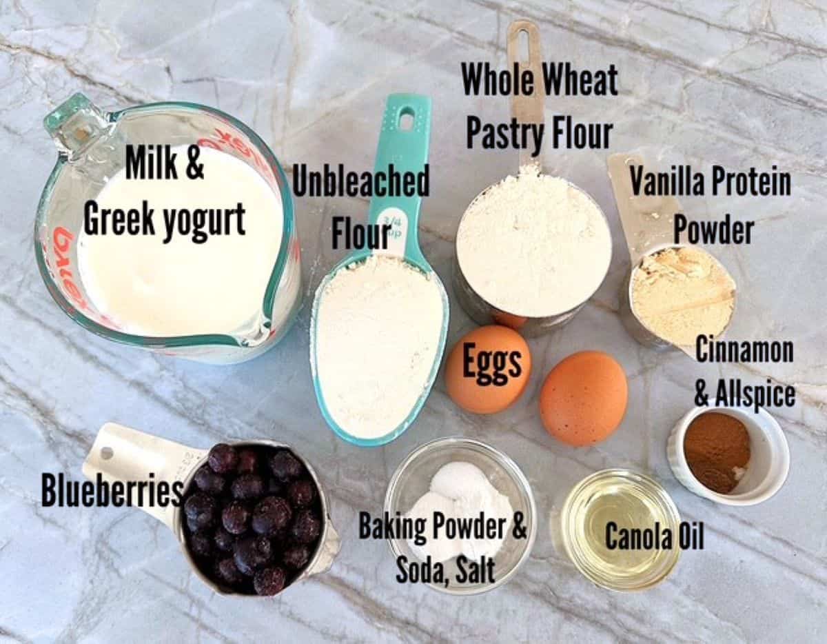Milk, yogurt, flour, protein powder, blueberries, etc. needed for high protein pancakes.