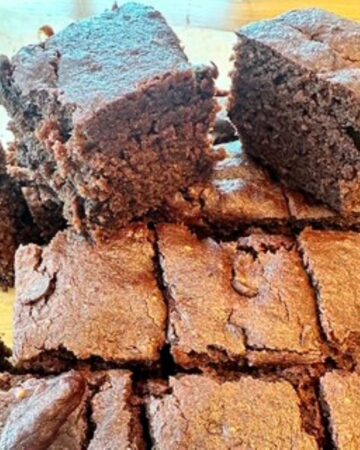 Close view of small dark chocolate brownie squares sweetened with date paste instead of sugar.