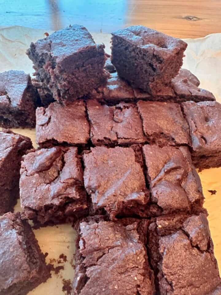 Dark brown chocolatey squares of brownies on a countertop.