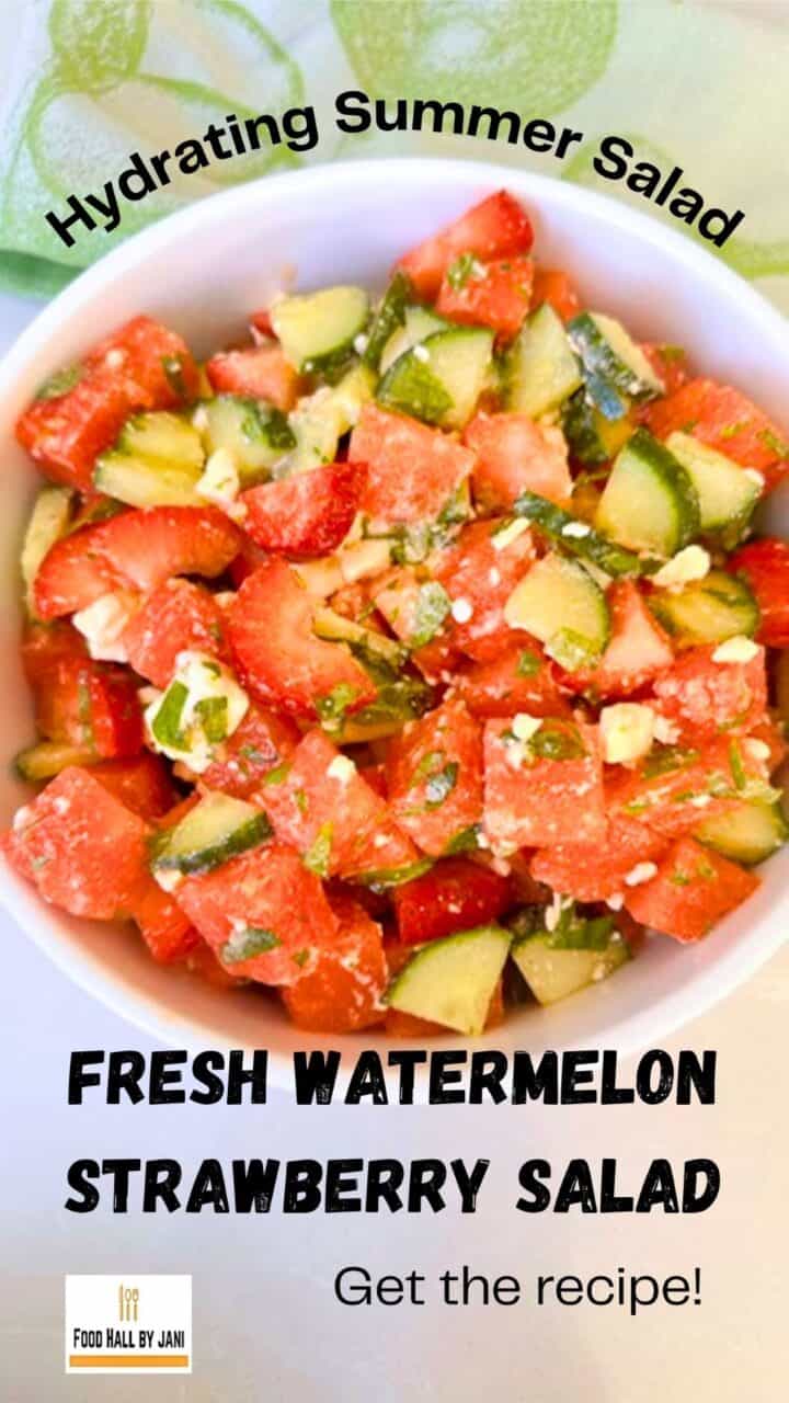 Bowl of juicy red and green watermelon strawberry cucumber salad with mint and white feta cheese.