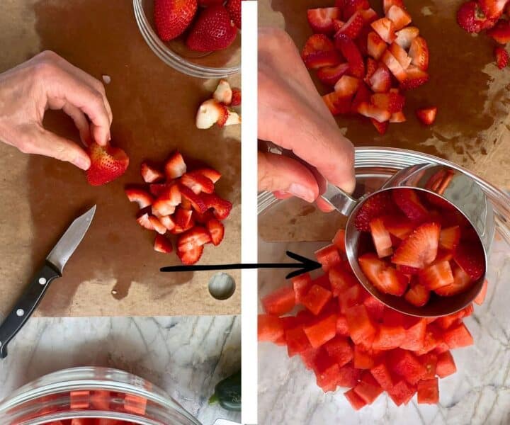 Red strawberries sliced on brown cutting board and placed in clear bowl with watermelon cubes.