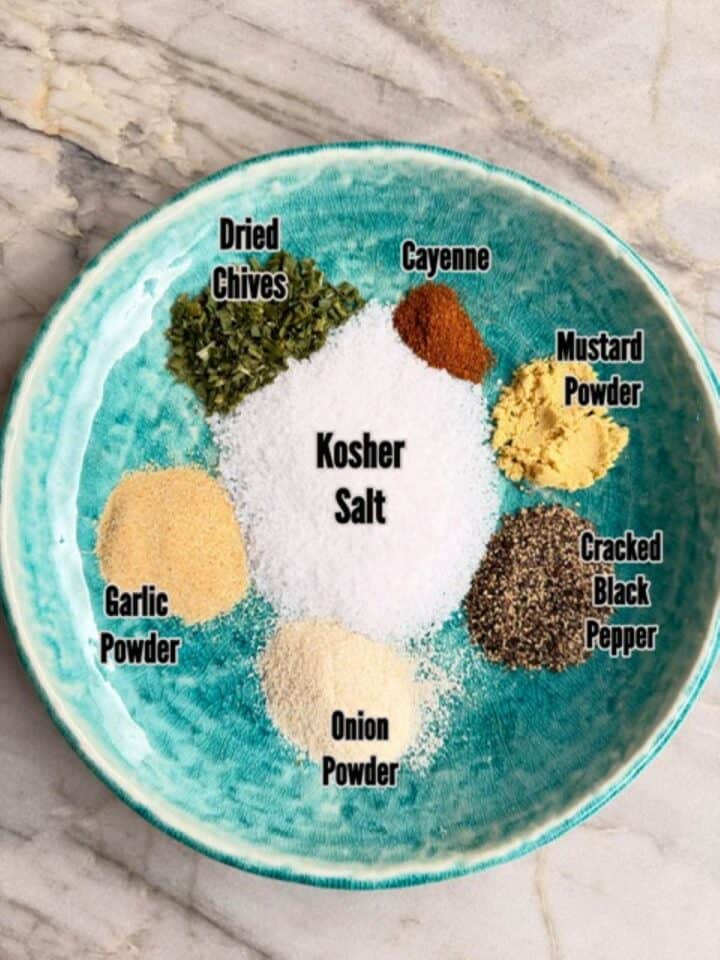 Assorted spices for burger seasoning including dried chives, cayenne, garlic, onion, black pepper, &. salt.