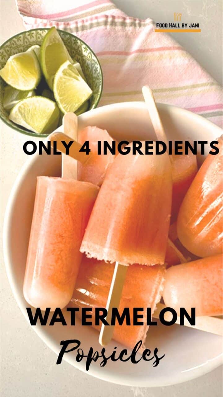 Creamy salmon-pink pops made of watermelon and coconut milk in a white bowl with limes on the side.