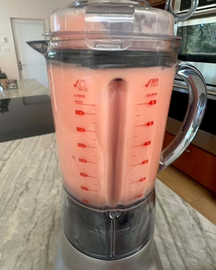 Creamy, pink watermelon-coconut milk puree fills a clear blender container.