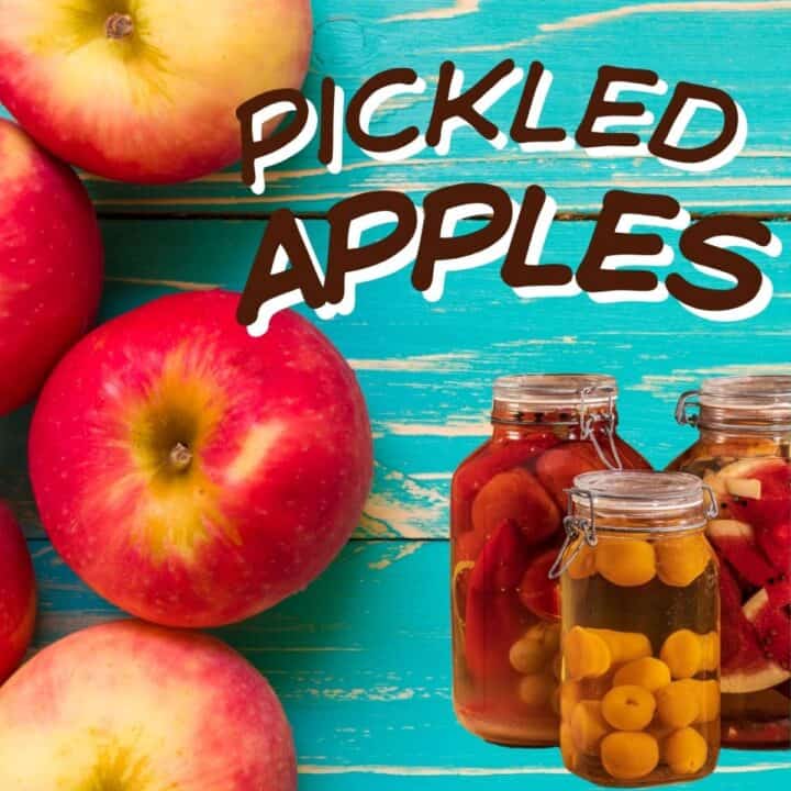 Blue table with whole red apples and inset jars of pickled fruits